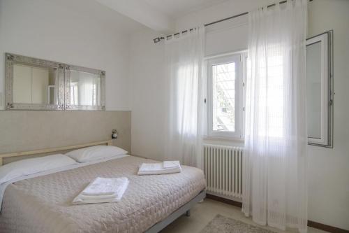 a bedroom with a bed with two towels on it at Appartamenti Federica in Milano Marittima