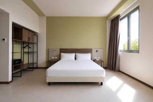 a bedroom with a white bed and a large window at LVG Hotel Collection - Belfiore in Mantova