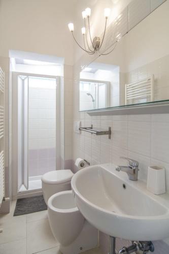 a white bathroom with a sink and a toilet at Appartamenti Federica in Milano Marittima