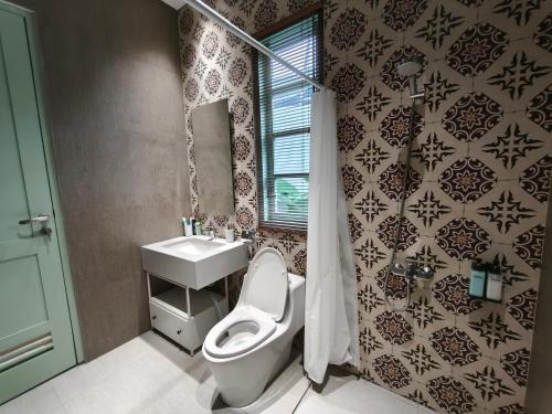 a bathroom with a toilet and a sink and a mirror at Dalem Kamulyan Kraton in Timuran