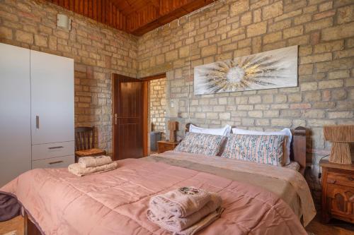 a bedroom with a large bed in a brick wall at Polilimnio Foteini's Mini Castle in Metamórfosis