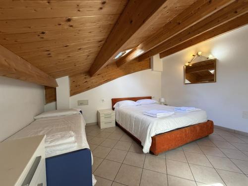 a bedroom with two beds and a wooden ceiling at Appartamenti Federica 5 in Milano Marittima
