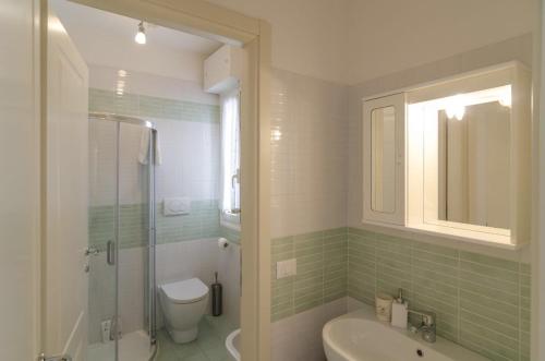 a bathroom with a shower and a toilet and a sink at Appartamenti Federica 5 in Milano Marittima