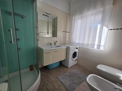 a bathroom with a sink and a washing machine at Appartamenti Federica 12P in Milano Marittima