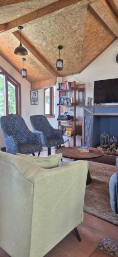 a living room with three chairs and a table at Roots & Rustle homestay in Kūfrī