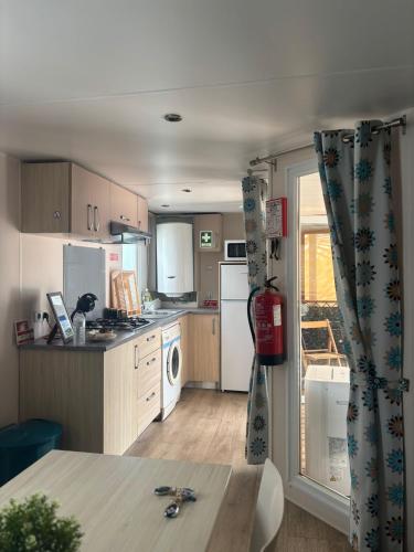 a kitchen with white appliances and a table in it at Quinta da Mariazinha in Fernao Ferro