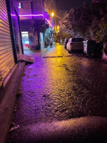 a cobblestone street at night with purple lights at Central Private Haven in Martil