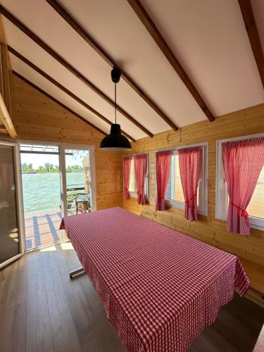 a bedroom with a red checkered bed with windows at Splav Sava in Ostružnica