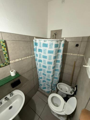 a bathroom with a sink and a toilet and a shower curtain at La Vecindad del Sol Depto G in Miramar