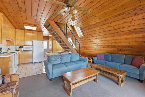 a living room with blue couches and a kitchen at Chalet #17 in Stevensville