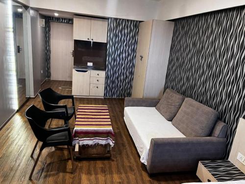 a living room with a couch and a kitchen at Weekend address in Surat