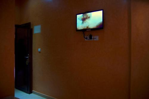 a flat screen tv on the wall of a room at Hotel Rimal Sahara in Laayoune