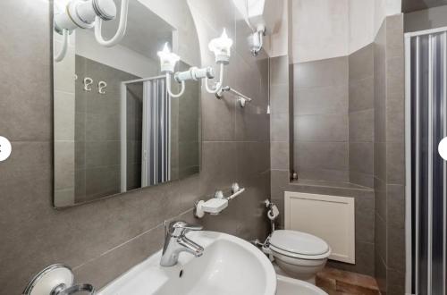 a bathroom with a sink and a toilet and a mirror at Charming LUCCA in Lucca