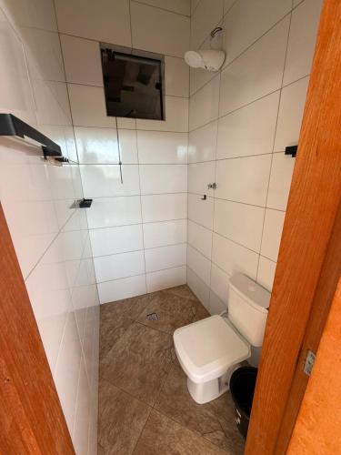 a small bathroom with a toilet and a shower at Recanto Feitosa Taubate in Taubaté