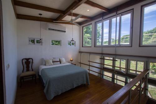 a bedroom with a bed in a room with windows at Hotel Ingigante in Rivas