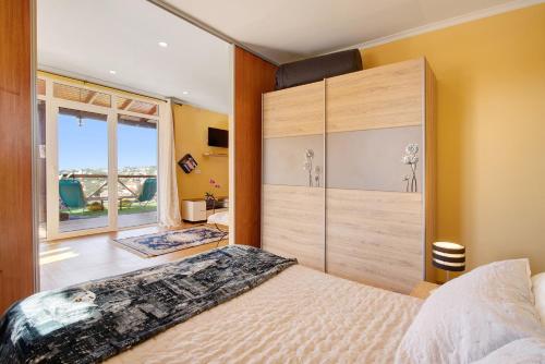 a bedroom with a large bed and a large window at Casa Carreira in Ponta do Sol