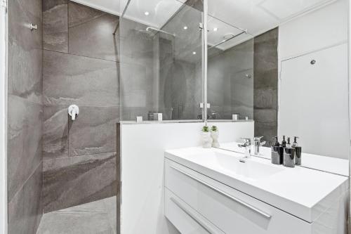 a bathroom with a white sink and a shower at Built on Hope De Waterkant in Cape Town