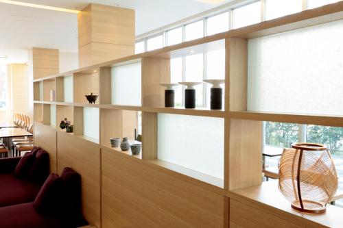a room with wooden shelves with vases on them at Candeo Hotels Handa in Handa