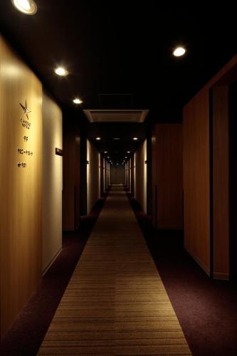 a dark hallway with a long hallwayngth at Candeo Hotels Handa in Handa
