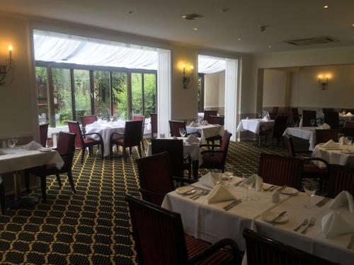 a restaurant with tables and chairs in it at Brook Mollington Banastre Hotel & Spa in Chester