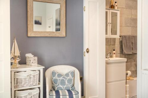 a bathroom with a mirror and a chair next to a sink at 2 Bed in Kingsteignton oc-w34194 in Kingsteignton