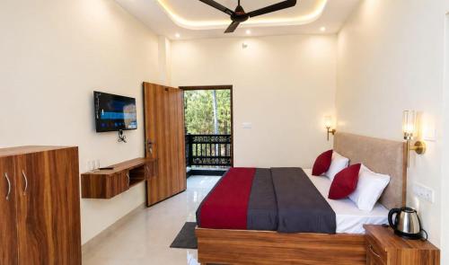 a bedroom with a large bed and a television at The Whistling Pine Homestay With Natural Swimming Pool in Lansdowne