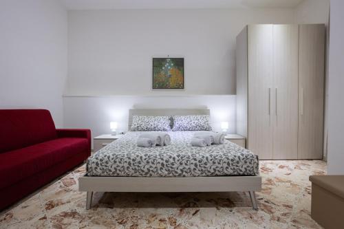 a bedroom with a bed and a red couch at A Casa di Paola B&B Lecce in Lecce