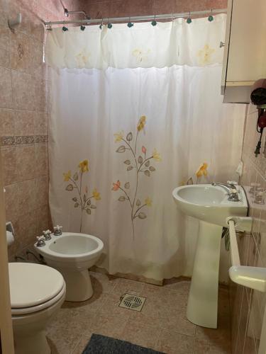 a bathroom with a shower curtain with a toilet and a sink at paldisfrute in Colón