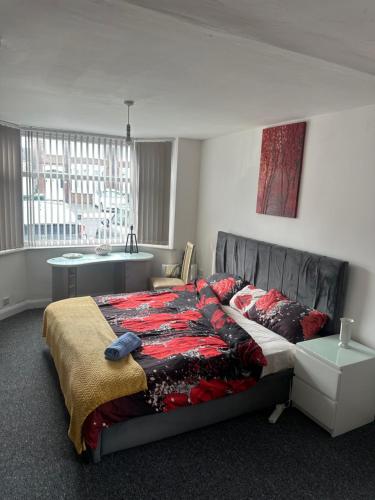 a bedroom with a bed and a table and a window at Quiet room Nr 1 in Coventry