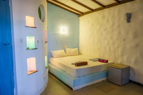 a small bedroom with a bed in a room at Tsunami beach hotel arugambay in Pottuvil