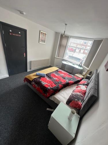 a bedroom with a bed and a couch and a window at Quiet room Nr 1 in Coventry