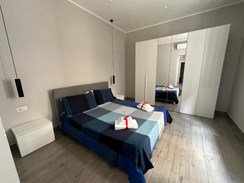 a bedroom with a blue bed with two shoes on it at Mazzini Home in Cosenza