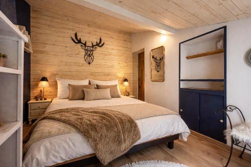 a bedroom with a bed with a antlers on the wall at Garden Lodge Formiguères in Formiguères