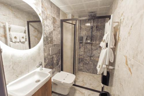 ein Badezimmer mit Waschbecken, Toilette und Dusche in der Unterkunft Hotel Milano in Rize