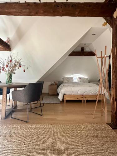 a bedroom with a bed and a table with a chair at studio 50m2 au bord de l'eau à STRASBOURG in Strasbourg