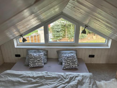 a bed in a small room with a window at Domeček pod lípou in Neveklov