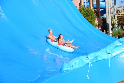 two people riding a water slide at a water park at Pickalbatros Jungle Aqua Park - Neverland Hurghada in Hurghada