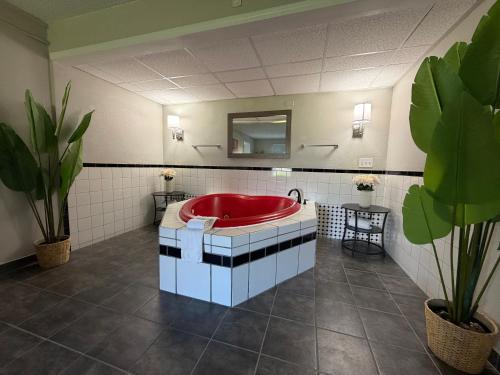 a bathroom with a red tub and a mirror at Whalers Inn and Suites in New Bedford