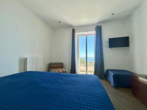 a bedroom with a blue bed and a window at Il Colle in Sanremo