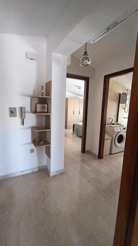 an empty living room with a kitchen and a microwave at L'Imperiale Granaio Casa Vacanze in Rocca Imperiale