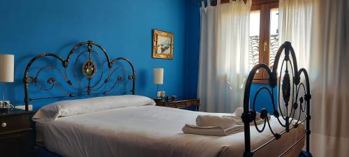 a bedroom with a bed with blue walls at La Casa de la Huerta in Vinuesa