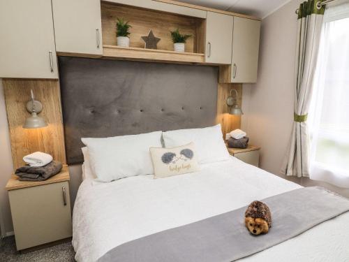 a bedroom with a bed with a dog laying on it at Hedgehog Lodge in Carnforth