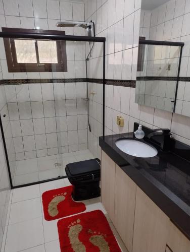 a bathroom with a sink and a toilet and a mirror at Hospedaria AlpenGlück in Treze Tílias