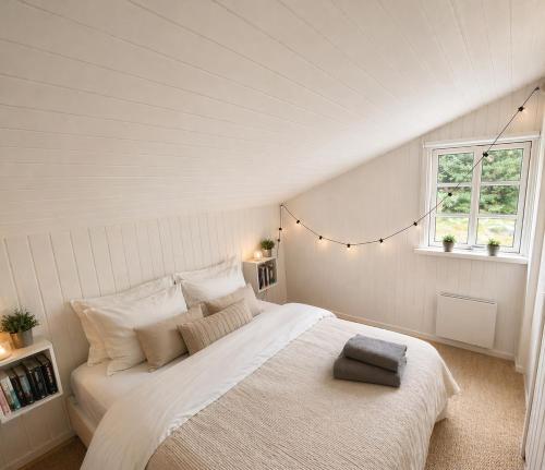 a bedroom with a large white bed in a attic at Cozy child-friendly house in Blokhus