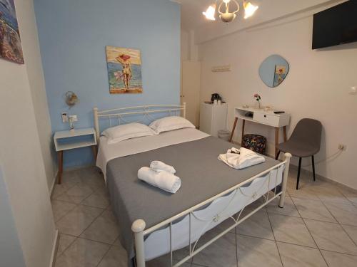 a bedroom with a bed with towels on it at Aegeon Pension in Aegiali