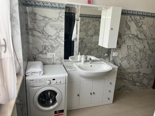 a bathroom with a washing machine and a sink at Casa Vacanze Leno in Leno