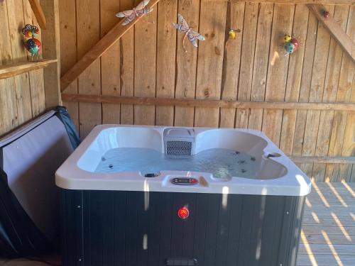 a jacuzzi tub in a wooden building at Cottage de La Mothe in Marnac