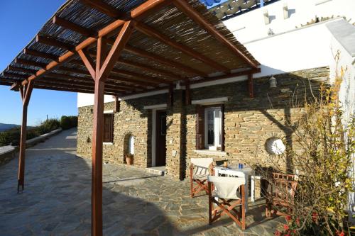 a wooden pergola over a patio of a house at Tinos Sky View Villa in Arnados