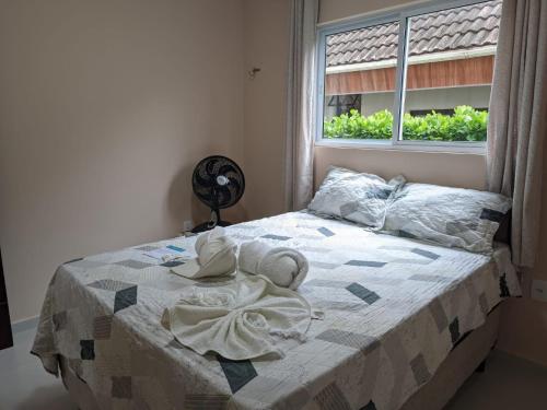 a bed with towels on it in a bedroom with a window at yes banana in Bananeiras