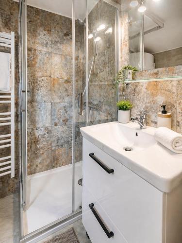 a bathroom with a white sink and a shower at Portki - Cztery Pory Roku in Pszczeliny